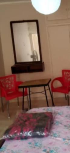 1 dormitorio con espejo, mesa y sillas en شقة الاسكندريه, en Alejandría
