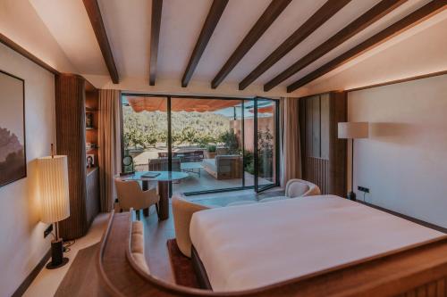 a bedroom with a bed and a view of a patio at Gran Hotel Mas d'en Bruno in Gratallops