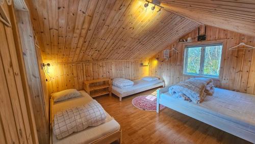 a room with two beds in a wooden cabin at Fjâllnäs Camping & Lodges in Ã–stra Malmagen