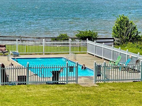 a swimming pool with people in it next to the water at P2 - Hot Springs 4 Bedroom Condo in Lake Hamilton