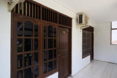 an empty room with a wooden door and a window at RedDoorz near Plaza Ambarrukmo Yogyakarta in Seturan