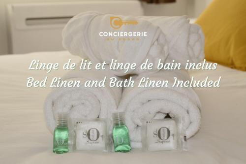 une photo de quelques serviettes et de deux bouteilles sur un lit dans l'établissement Le Green - Clim et Emplacement, à Nîmes