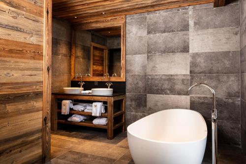 a bathroom with a tub and two sinks at M Lodge & Spa in Saint-Martin-de-Belleville