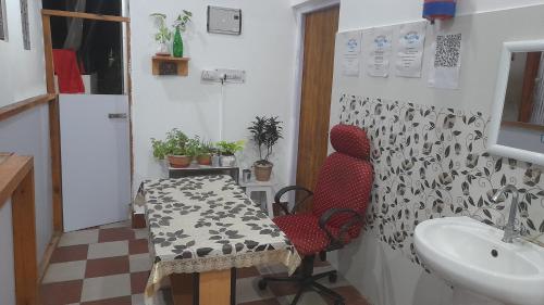 a bathroom with a table and a chair and a sink at MOHAN GANGA VIEW HOMESTAY in Uttarkāshi