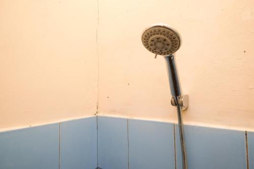 un cabezal de ducha en la pared del baño en RedDoorz near Plaza Ambarrukmo Yogyakarta en Seturan