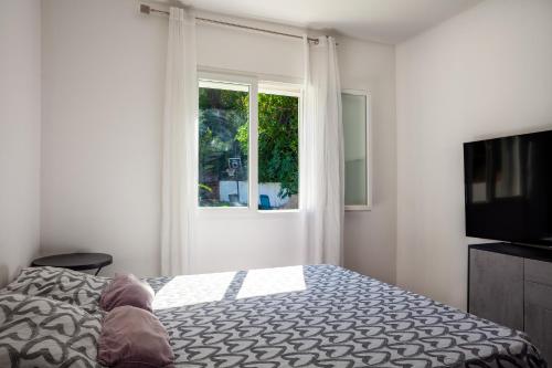 - une chambre avec un lit, une télévision et une fenêtre dans l'établissement Villa au calme avec piscine, à Méounes-lès-Montrieux