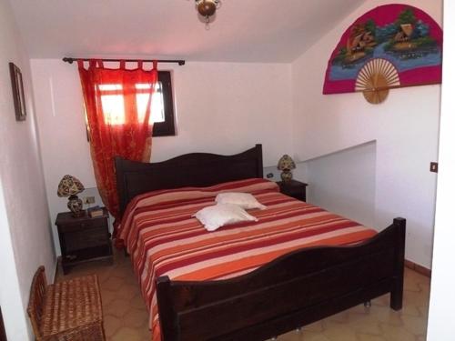 サンタンティーオコにあるCalasapone Holiday Homeのベッドルーム1室(ベッド1台、赤と白の毛布付)