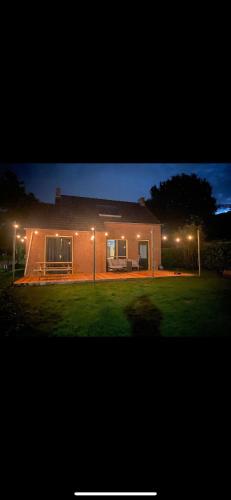 a house with lights on the side of it at night at Vakantiehuis de Bruyn 6 persoons in Ewijk