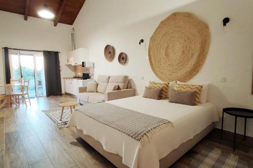 a bedroom with a large bed and a living room at Monte das Fontainhas in Pêra