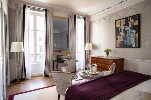 a bedroom with a bed and a table and chairs at La Réserve Paris Hotel & Spa in Paris
