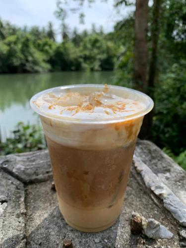 a cup of iced coffee sitting on a table at Krua Chehe Resort ครัวเจ๊ะเห รีสอร์ท in Ban Khok Muang