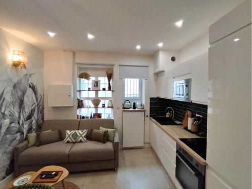 un salon avec un canapé et une cuisine dans l'établissement Le Green - Clim et Emplacement, à Nîmes