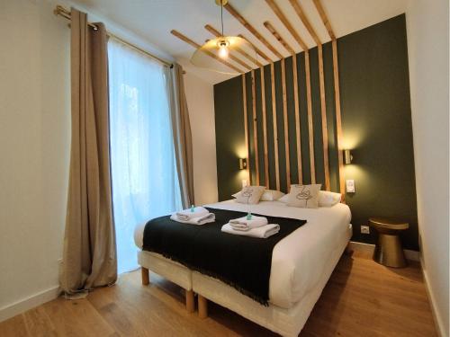 une chambre avec un lit avec deux serviettes dessus dans l'établissement Le Green - Clim et Emplacement, à Nîmes