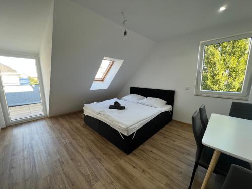 維也納的住宿－Semi 3a Neubauwohnung in Wien für 4 Personen，一间卧室配有一张床、一张桌子和两个窗户
