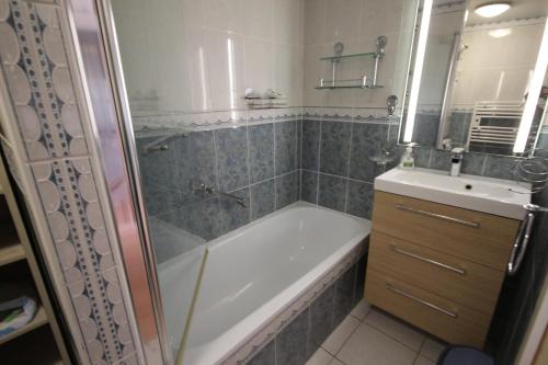 une salle de bain avec une baignoire et un lavabo dans l'établissement Belle villa 5 couchages 2 chambres 2 terrasses piscine commune dans résidence securisée à 200m de la mer LRMA23, à Portiragnes