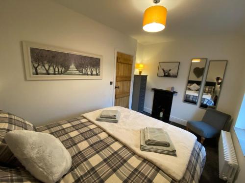 a bedroom with a bed and a chair and a fireplace at Angel's Cottage in Buxton