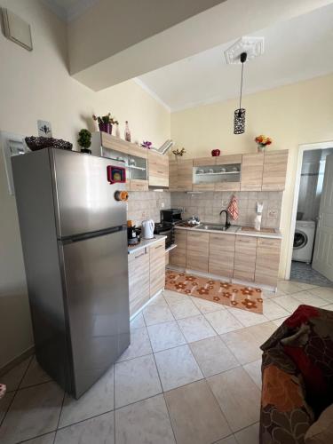 a large kitchen with a stainless steel refrigerator at See and City Apartment in Aigio