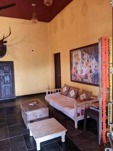a bedroom with a bed and a table in it at Vanacara in Sawantwadi