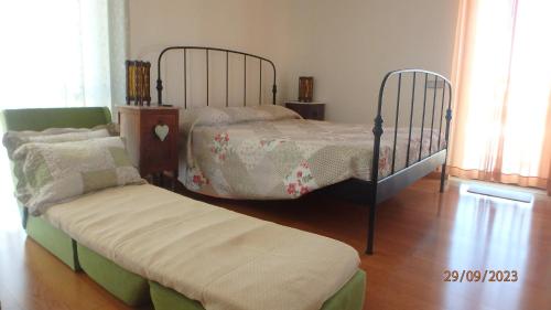 a bedroom with two twin beds and a bench at Suite na Casa da Andreia in São Martinho do Porto