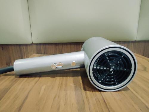 a silver fan sitting on a wooden floor at Jenny airport lounge in Vientiane
