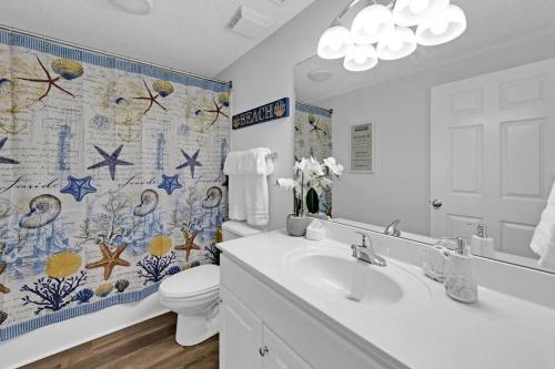 a bathroom with a sink and a toilet and a shower curtain at Beachfront Studio #909 at Majestic in Panama City Beach
