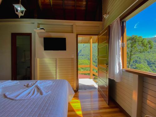 a bedroom with a bed and a sliding glass door at Pousada Bugio da Serra in Novo Horizonte