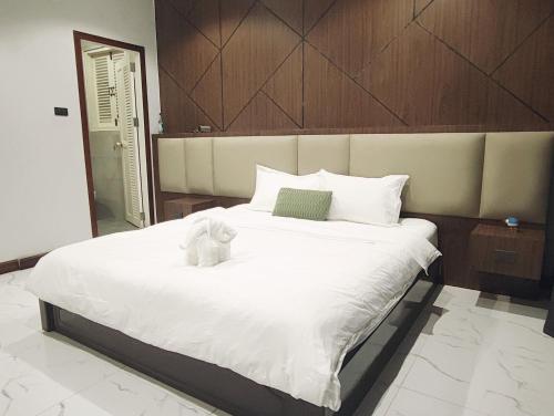 a white teddy bear sitting on a large bed at Jenny airport lounge in Vientiane