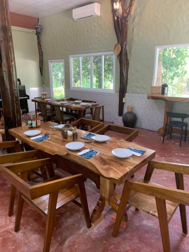 une salle à manger avec une table et des bancs en bois dans l'établissement Krua Chehe Resort ครัวเจ๊ะเห รีสอร์ท, 