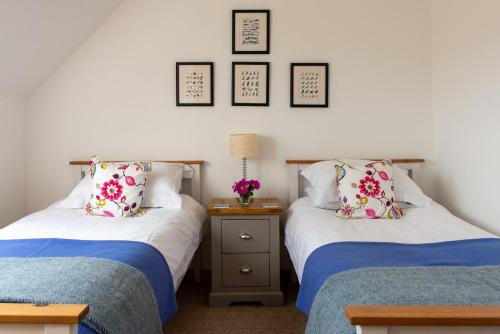 dos camas sentadas una al lado de la otra en una habitación en Shore Croft, en Aultbea