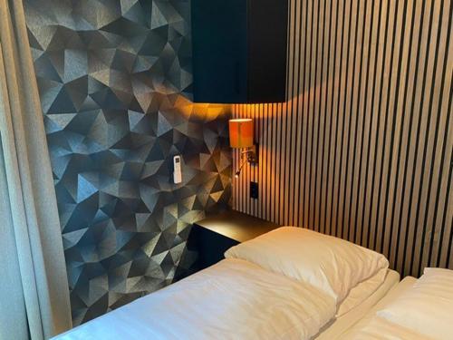 um quarto com uma cama e uma parede geométrica em Wellnesslodge Merel em Dalerveen