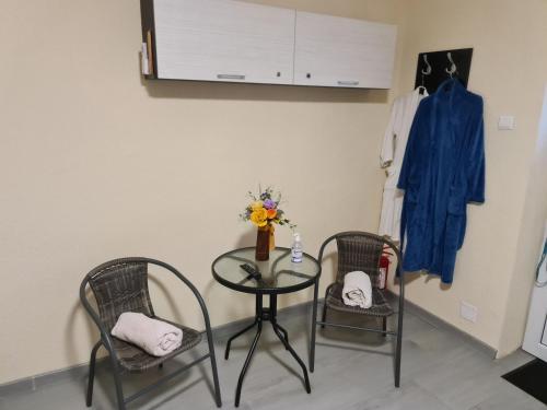 a table with two chairs and a table with a vase at Motel in Diosig