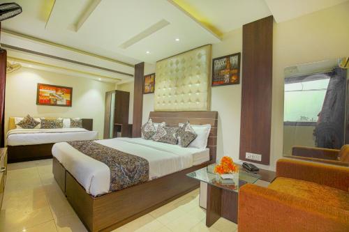 Habitación de hotel con 2 camas y sofá en VK Hotels & Resorts en Amritsar