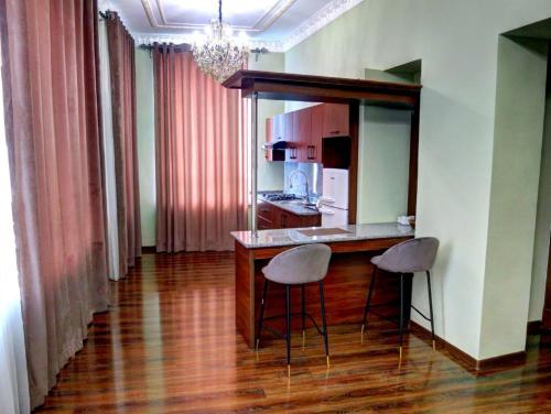 a kitchen with a counter and two stools in a room at Sangzor Boutique Hotel in Samarkand
