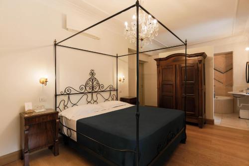 a bedroom with a black canopy bed with a chandelier at Albergo Ristorante Madonnina in Cantello