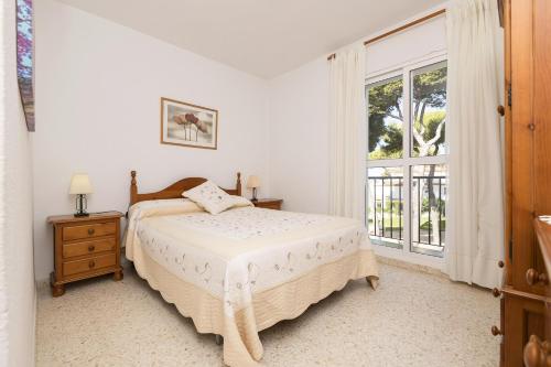 a bedroom with a bed and a large window at Casa Ocon in Conil de la Frontera