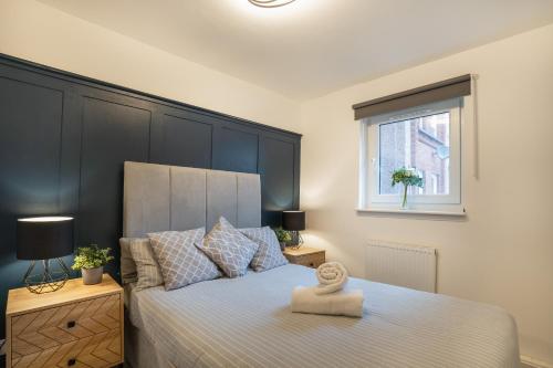 a bedroom with a bed with a large black headboard at Modern 2BED Apartment-Free Parking in Edinburgh