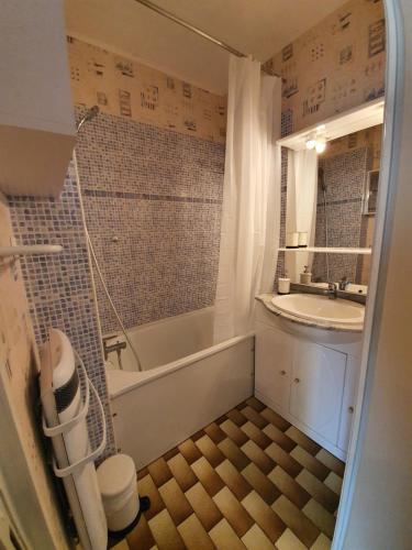 une petite salle de bain avec une baignoire et un lavabo dans l'établissement Valras-plage studio cabine 100m de la plage, à Valras-Plage