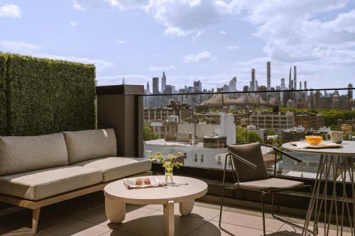 a balcony with a couch and a table and a city at Sonder The Dutch in Long Island City