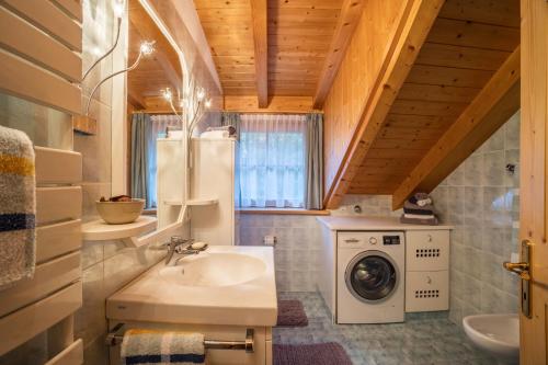 uma casa de banho com um lavatório e uma máquina de lavar roupa em Adulty Only Wasserfall Tschorn em Fundres