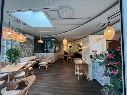 um restaurante com mesas e cadeiras e vasos de plantas em Ace Inn Shinjuku em Tóquio