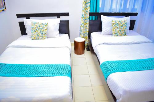 2 letti posti uno accanto all'altro in una stanza di Bomani Penthouse a Kisumu