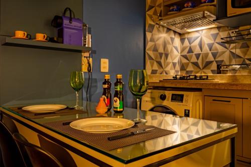 uma cozinha com uma mesa com um prato e dois copos de vinho em Espaço Comfort Sudoeste, confortável e silencioso em Brasília