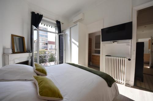 um quarto com uma cama grande e uma televisão de ecrã plano em 4P Terrasse, Palais à 500 m, Charme Bourgeois em Cannes