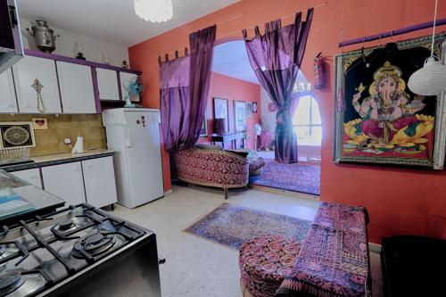 a kitchen with pink walls and a kitchen with a refrigerator at chaisheeka in Mellieħa