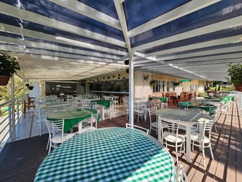 um pátio com mesas e cadeiras verdes e brancas em Hotel Fazenda Pommernland em Pomerode
