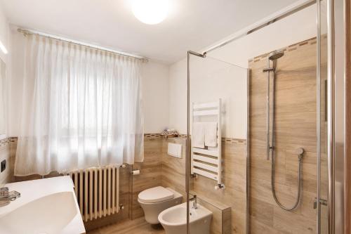 een badkamer met een douche, een toilet en een wastafel bij Casa Silvia in Livigno