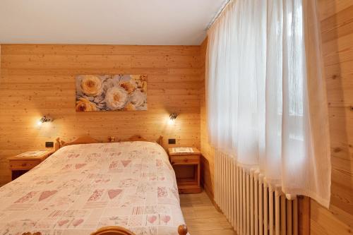 een kleine slaapkamer met een bed en een raam bij Casa Silvia in Livigno