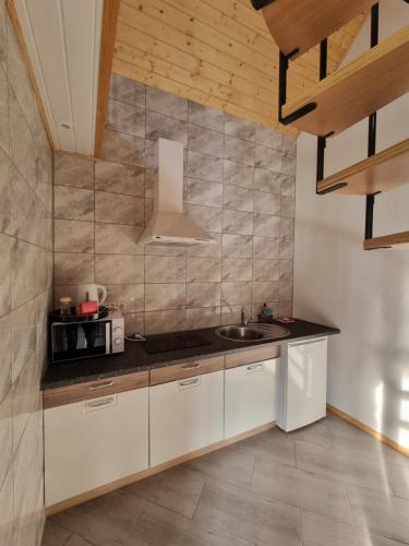 a kitchen with white cabinets and a sink at Sodyba "Kristina" in Biržai