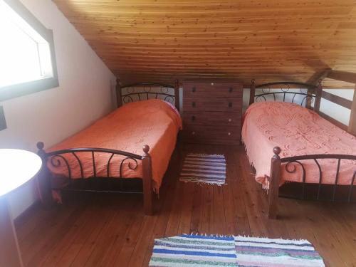 two beds in a room with wooden floors at The Mouflon House Pedoulas in Nicosia