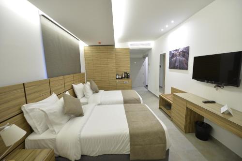 a hotel room with two beds and a flat screen tv at Zett hotel in Jounieh